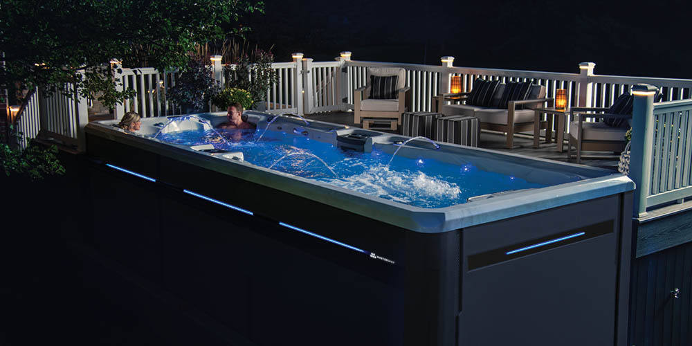 Spa de natación H2X Challenger por la noche junto a una terraza.
