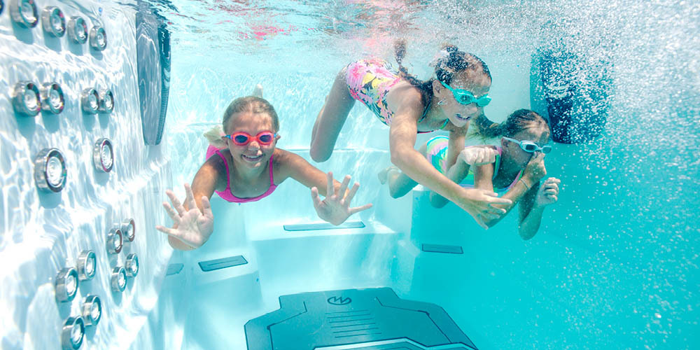 Fotografía submarina de unos niños disfrutando de un spa de natación.